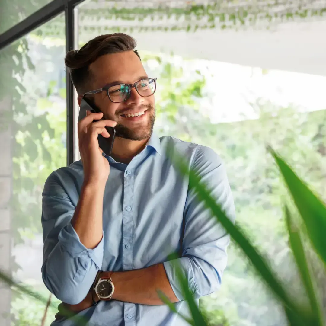 Consulente sorridente con occhiali durante telefonata di supporto clienti in ufficio