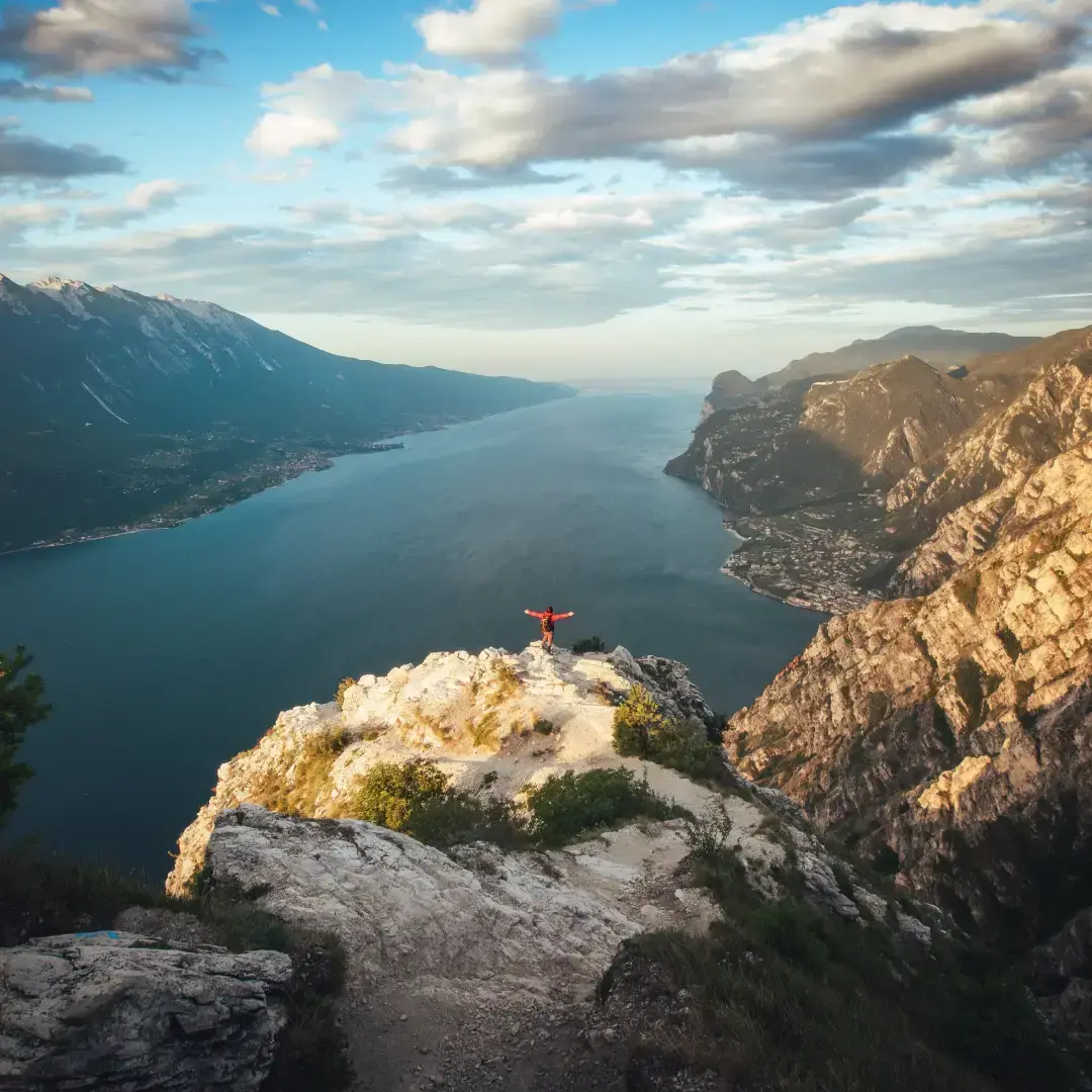 Vista panoramica sul Lago di Garda dalle montagne con escursionista sulla vetta