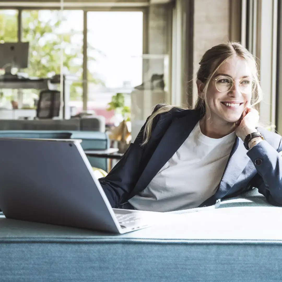 Operatrice sorridente con laptop in un ufficio moderno luminoso