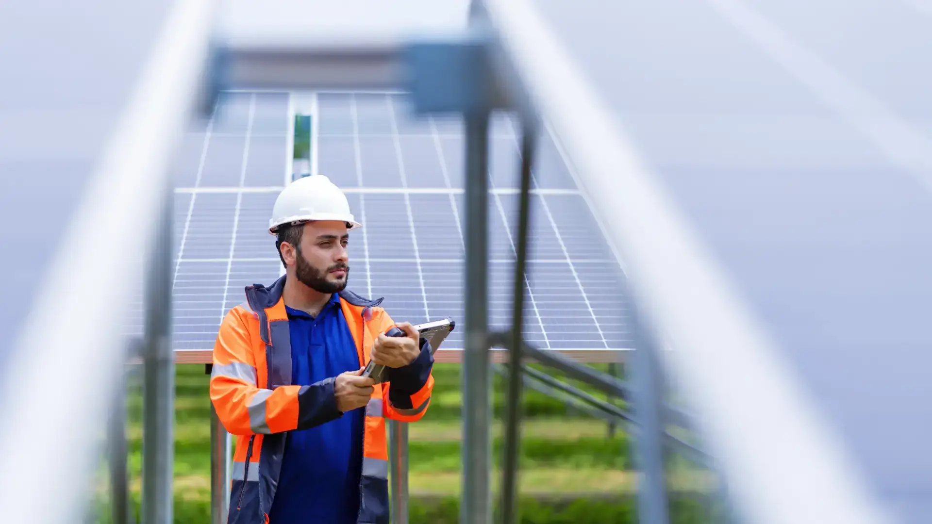 Tecnico con elmetto e tablet durante ispezione di impianto fotovoltaico